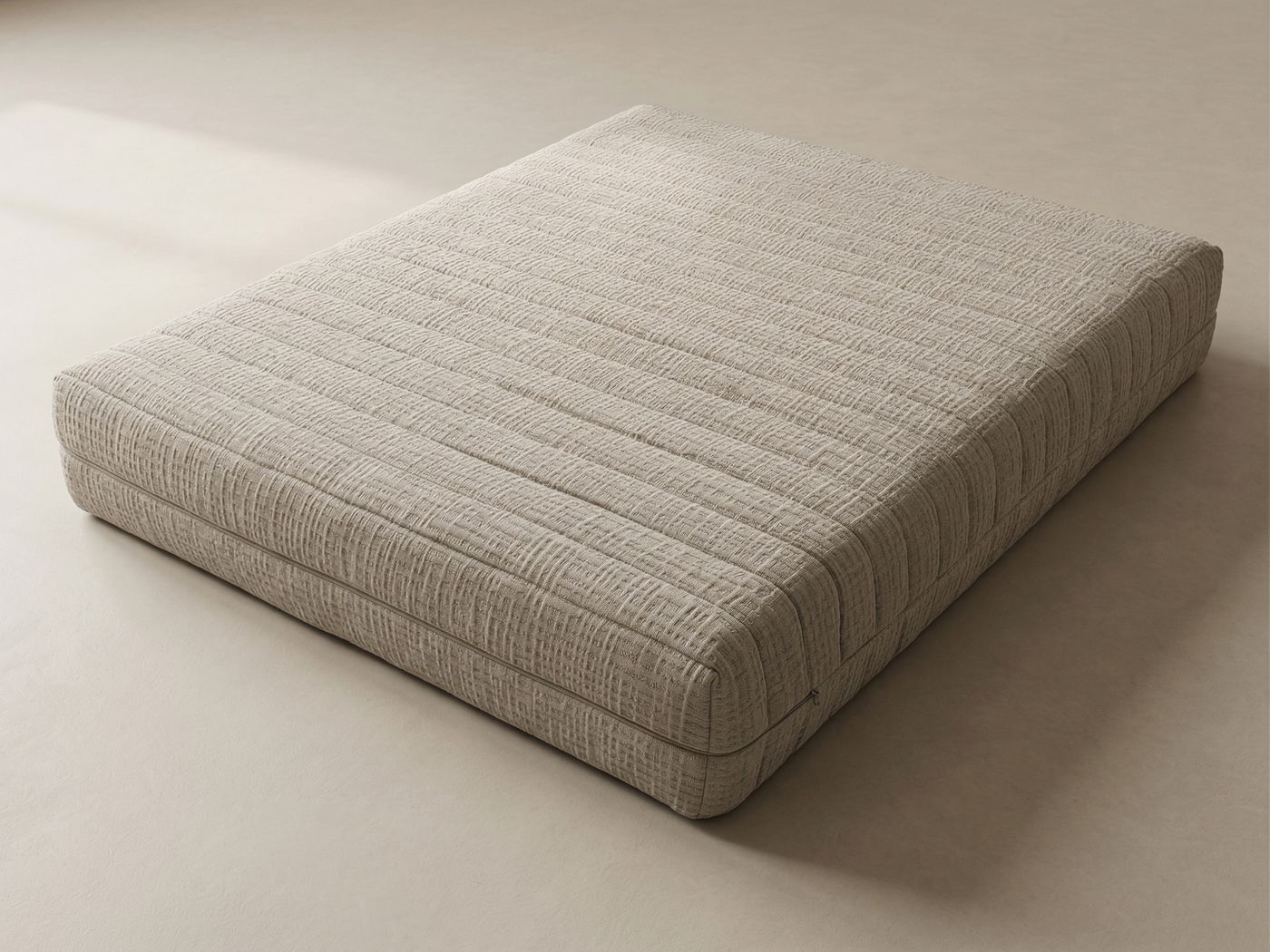 A mattress in a textured beige cover
